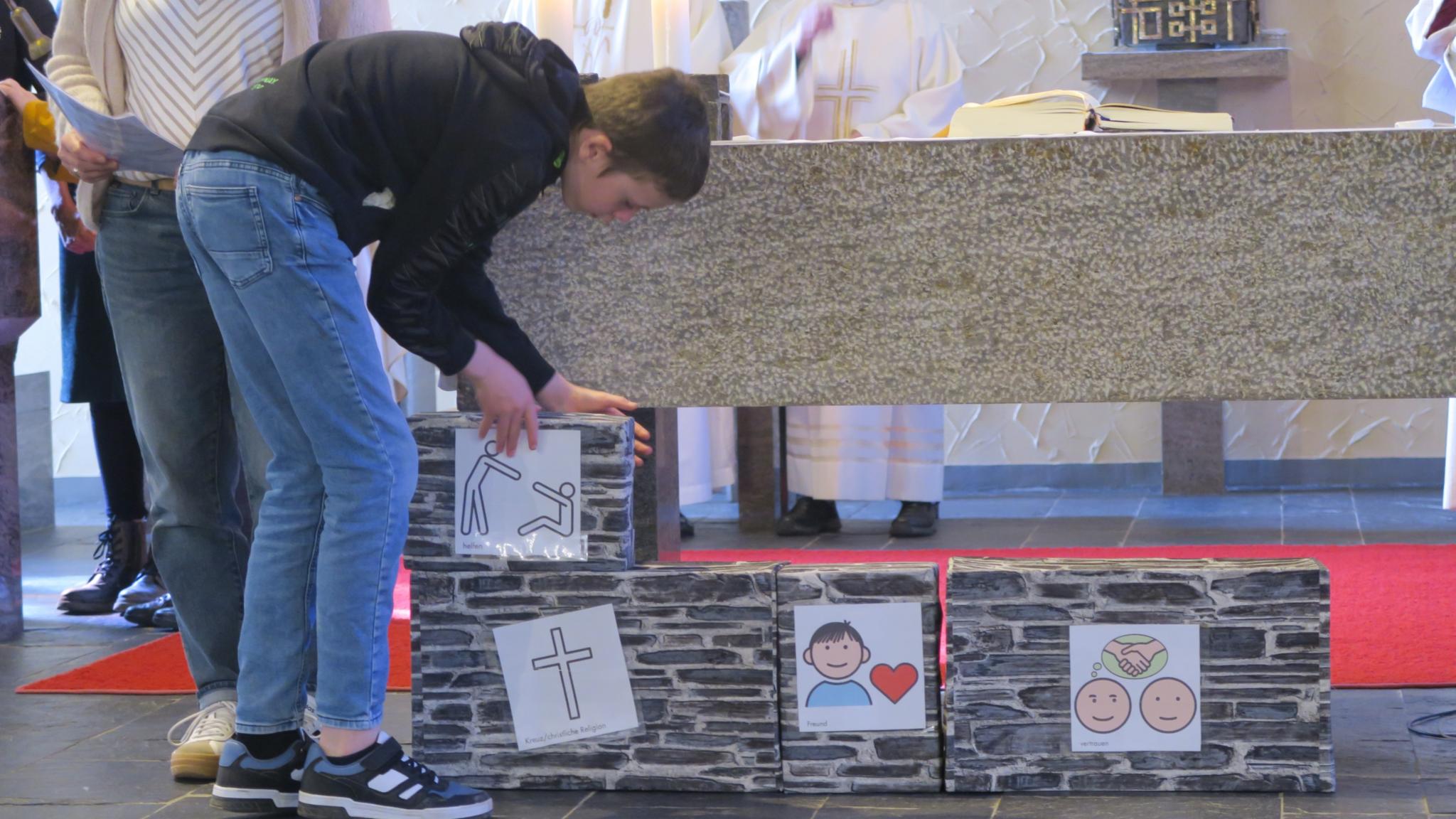 Schüler und Schülerinnen der Förderschule St. Martin bauten während des Gottesdienstes symbolisch das Haus, dessen Fundament vor 60 Jahren gelegt wurde.