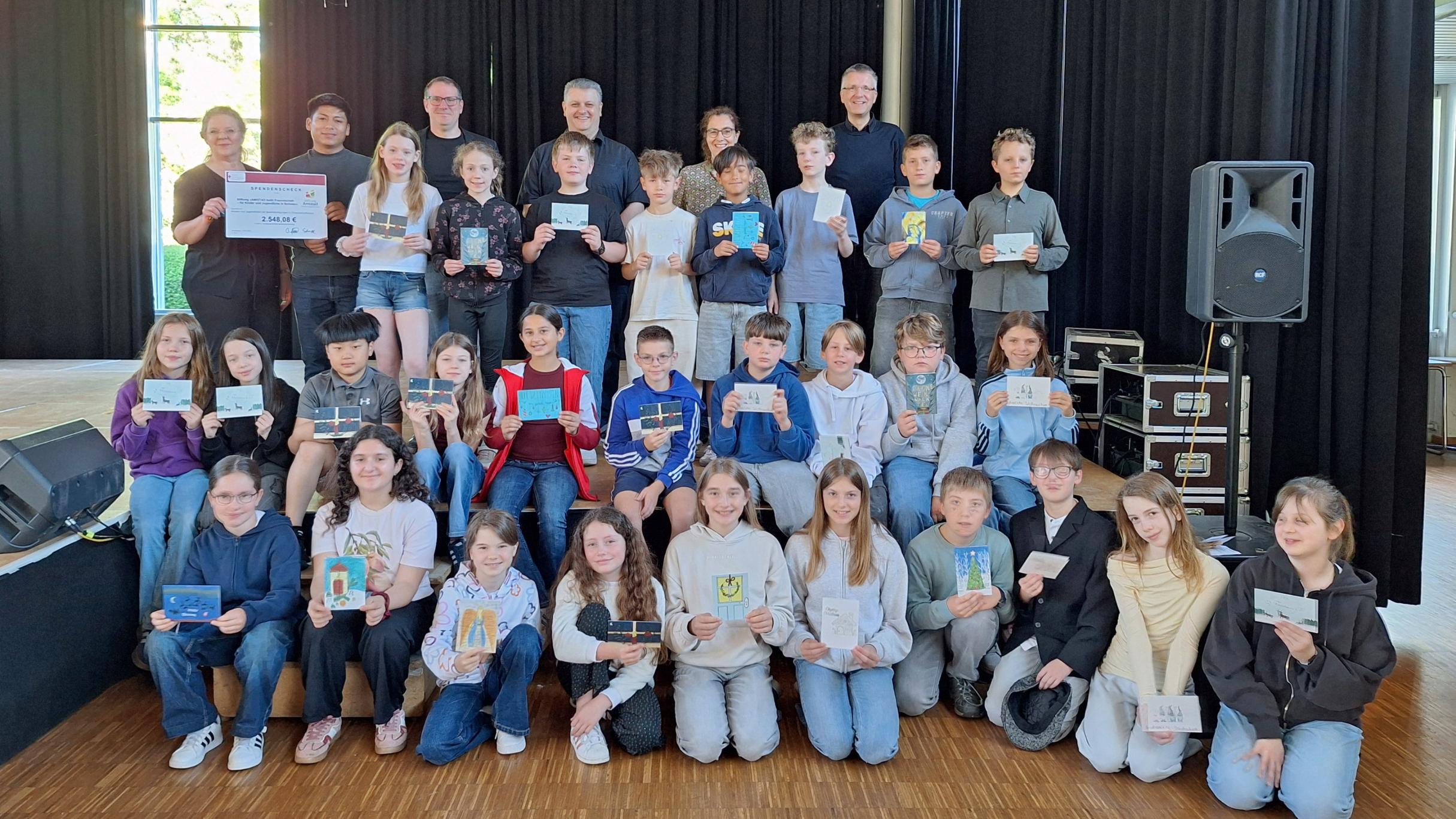 Annemarie Reimers (Leiterin Didaktik am Willi-Graf Gymnasium), Kevin Daniel Vallejos (Freiwilliger), Stephan Arnold (Schulleiter der Willi-Graf-Realschule), Christian Dahlke (Schulleiter des Willi-Graf-Gymnasiums), Evelyn Zimmer (Abteilung Jugend) und Bernd Schütz (Schulpfarrer) gemeinsam mit Schülerinnen und Schülern der Willi-Graf-Schulen bei der Spendenübergabe.