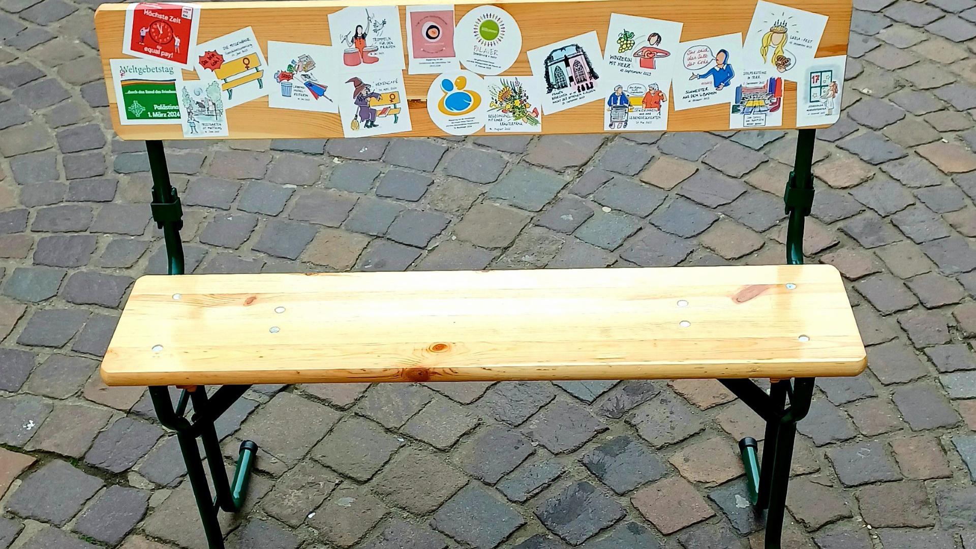 Eine Sitzbank, die mit Aufklebern beklebt ist.