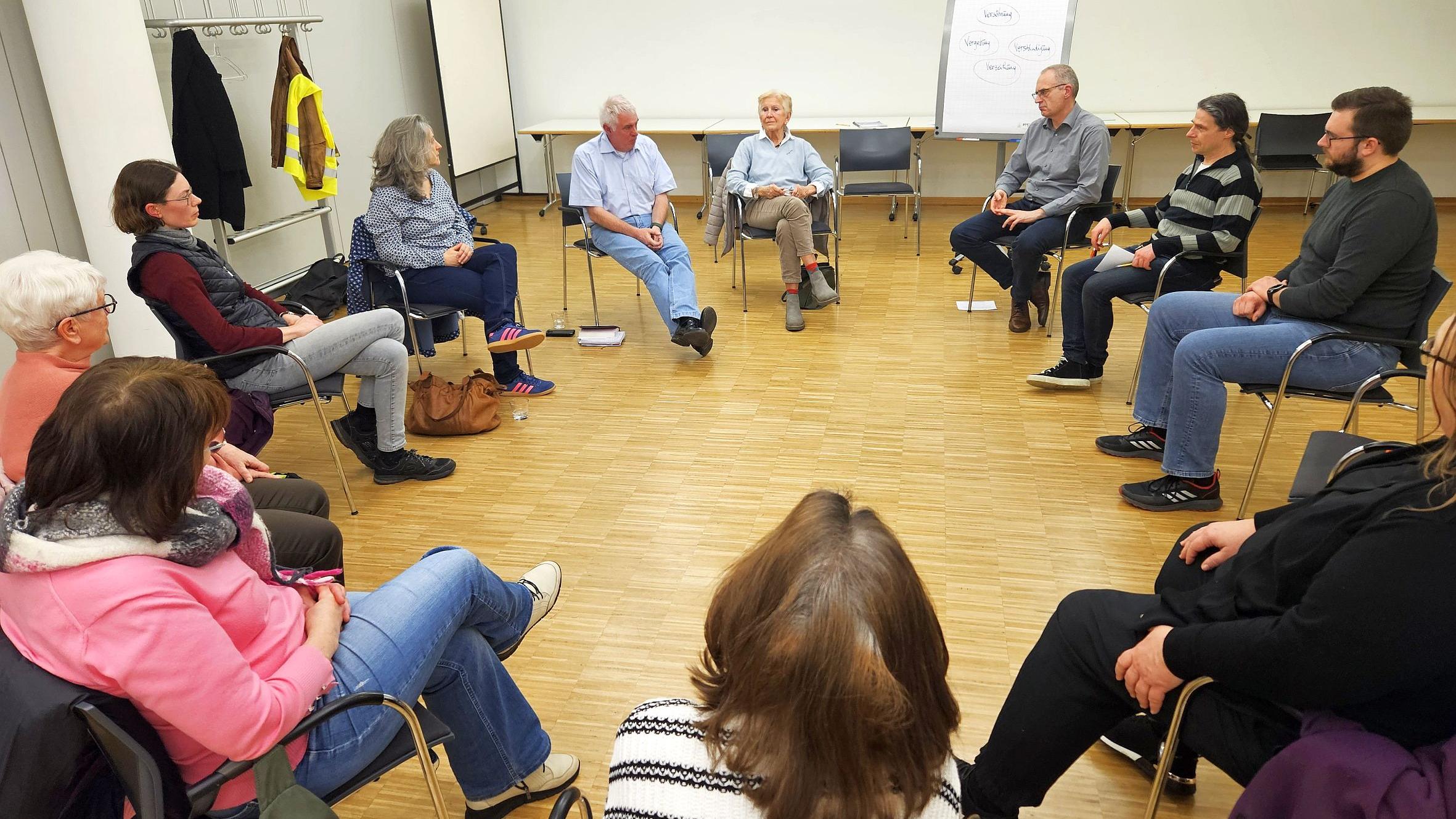 Menschen sitzen im Kreis und unterhalten sich