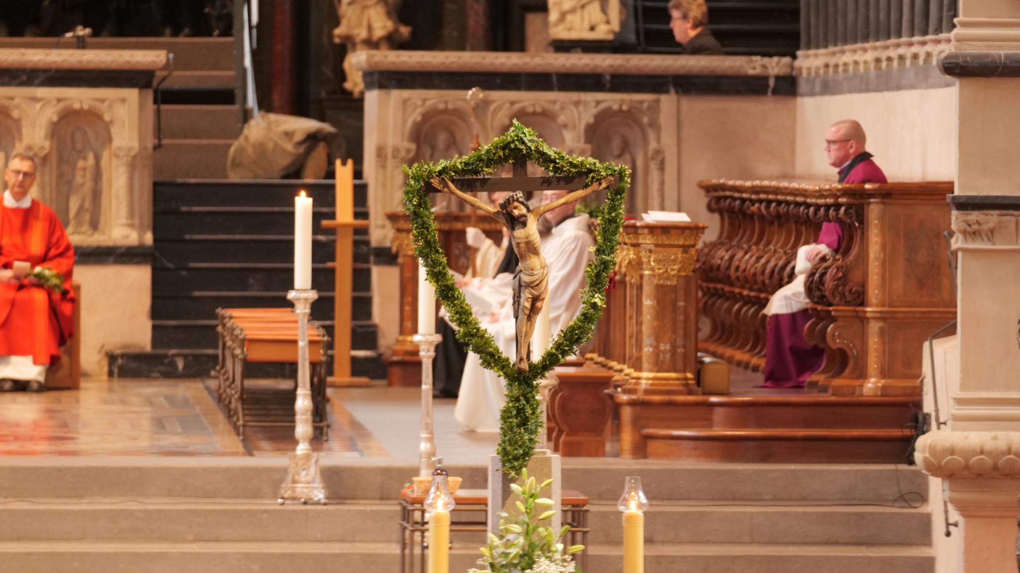 Das Kreuz mit Jesus ist umgeben von Palmzweigen