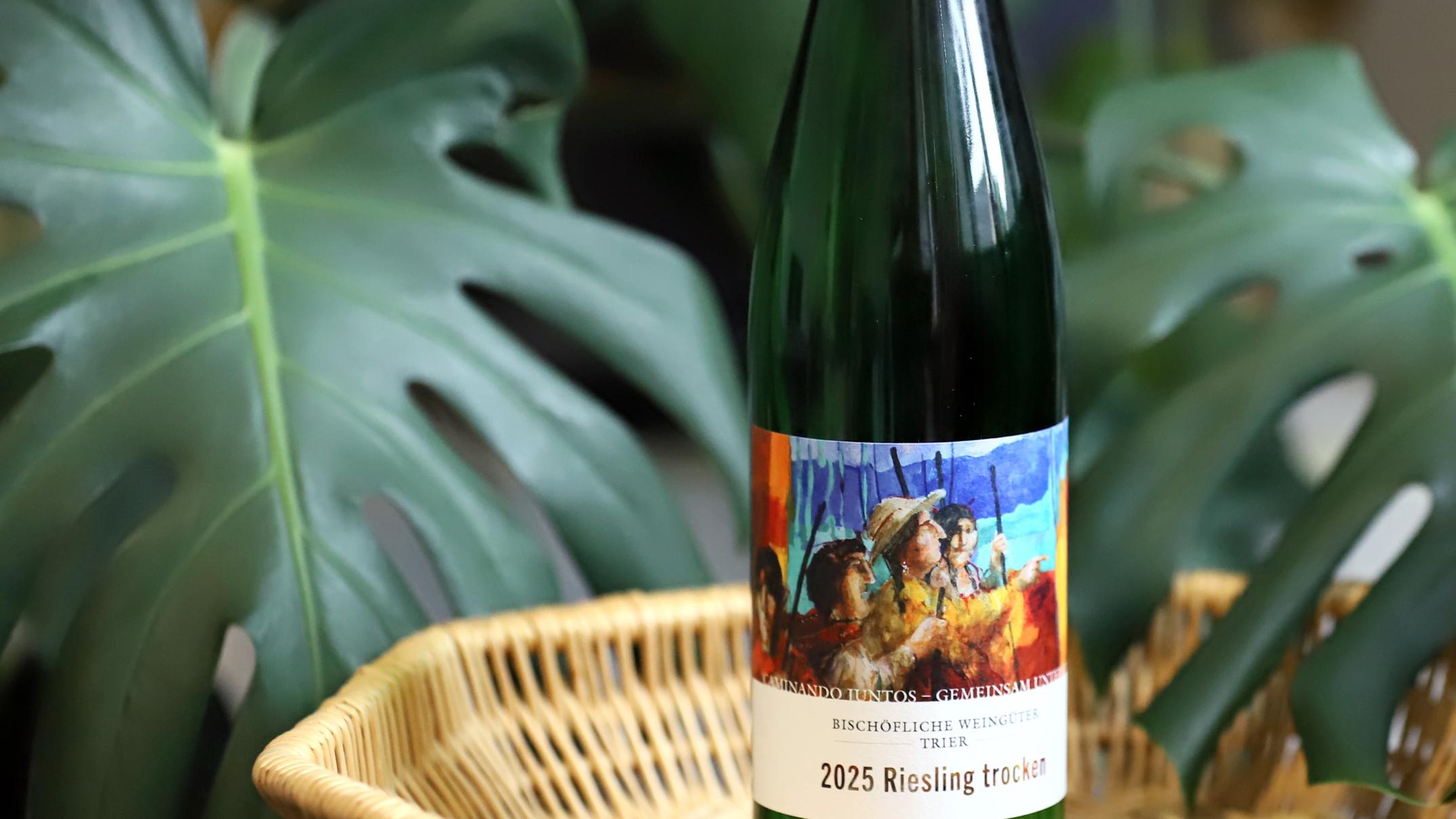 Eine Flasche Partnerschaftswein steht auf einem Tablett. Im Hintergrund eine Pflanze