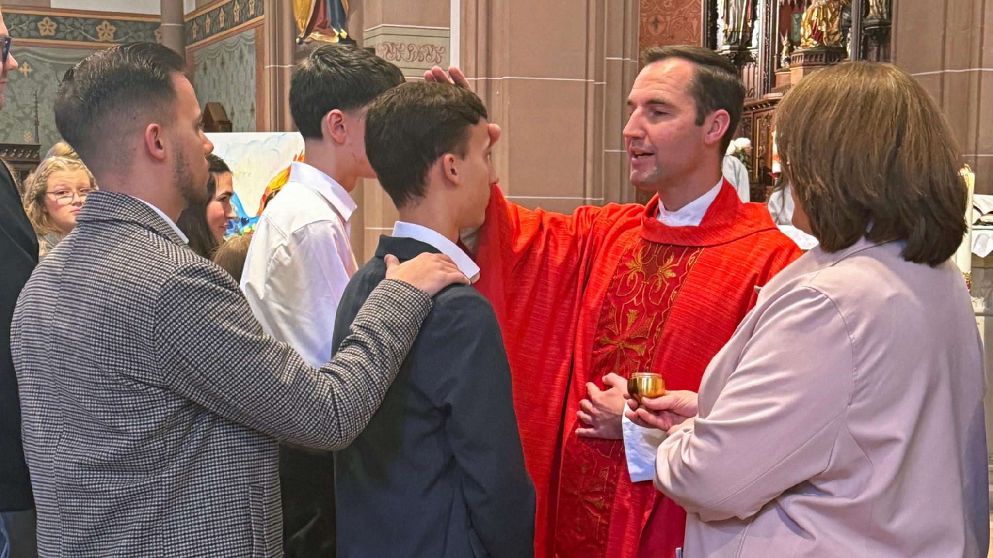 Peter Zillgen spendet Jugendlichen das Firmsakrament und salbt sie mit Chrisamöl (Archivfoto aus 2025)