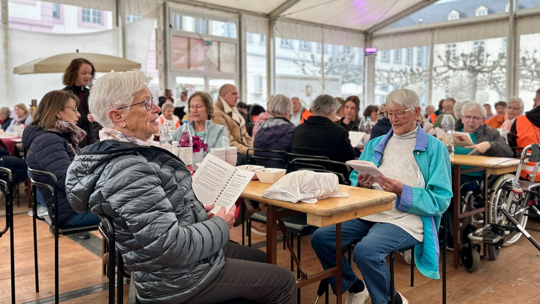 Seniorinnen und Senioren singen im Begegnungszelt