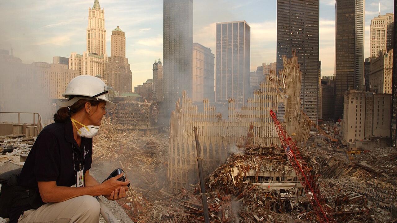 Eine Frau sitzt vor den Trümmern des World Trade Centers